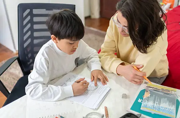Élève suivant un cours en ligne sur ordinateur avec un professeur